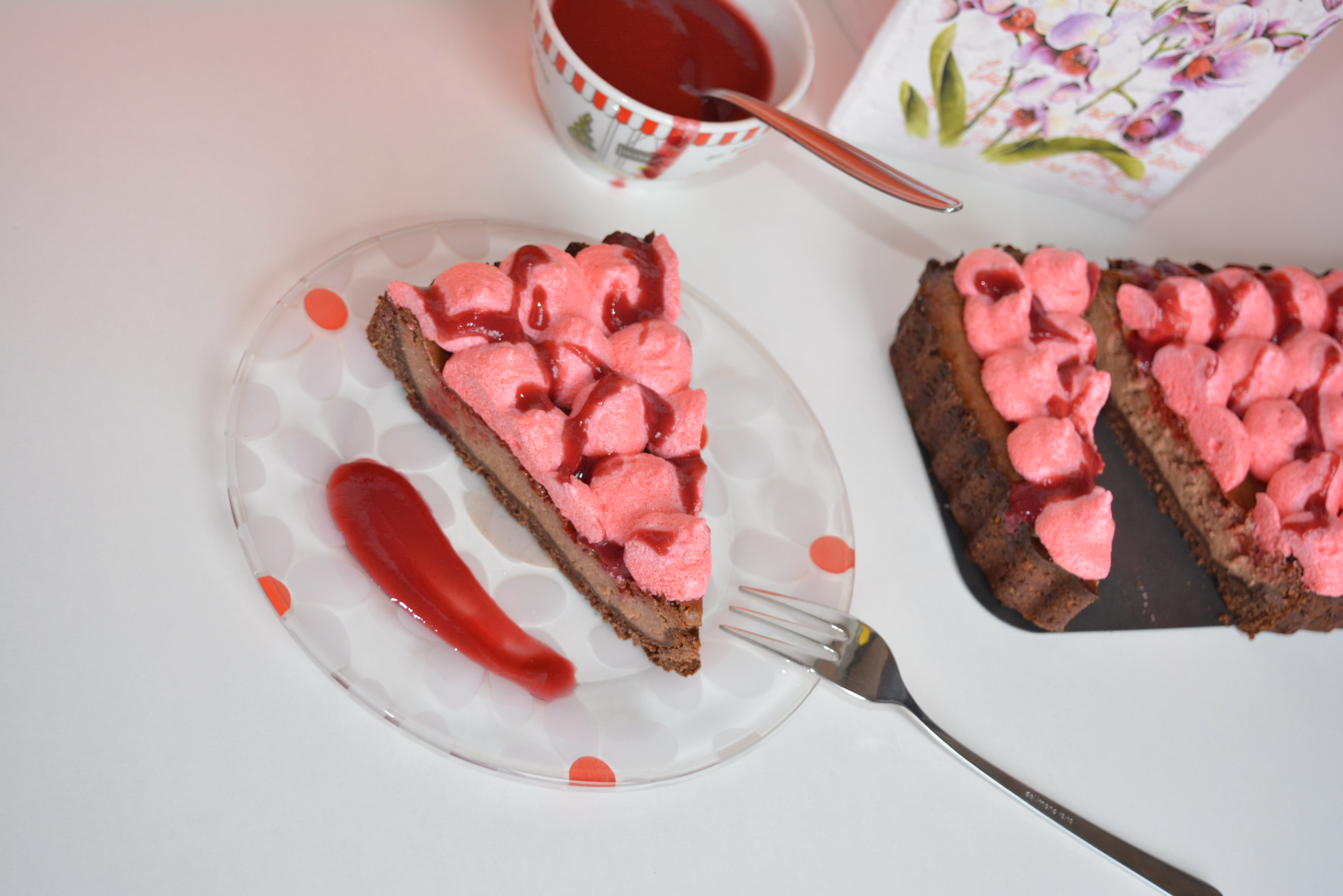 Cheesecake cu ciocolata, bezea rosie si coulis de zmeura