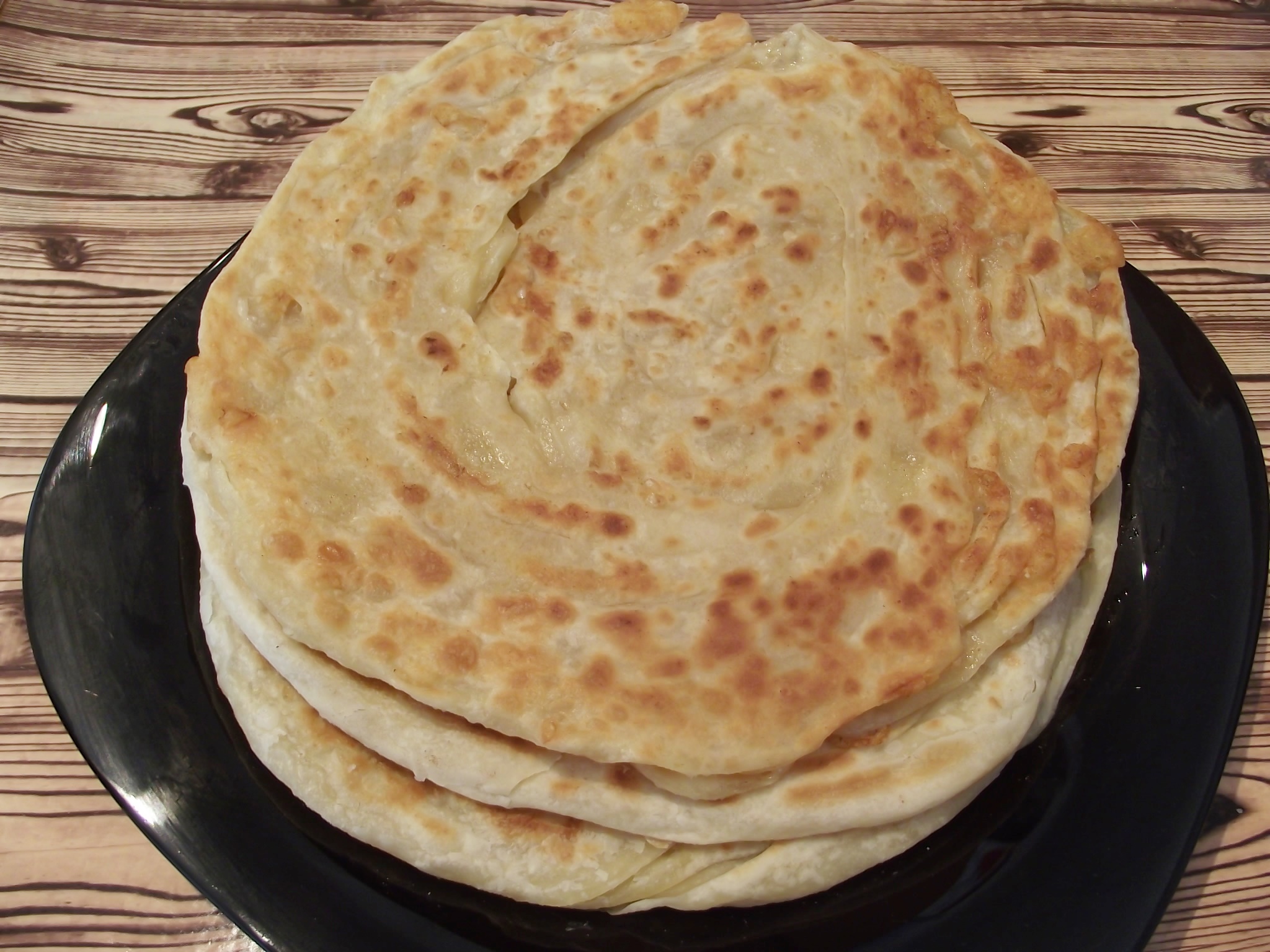 Paratha sau paine plata foietajata preparata la tigaie