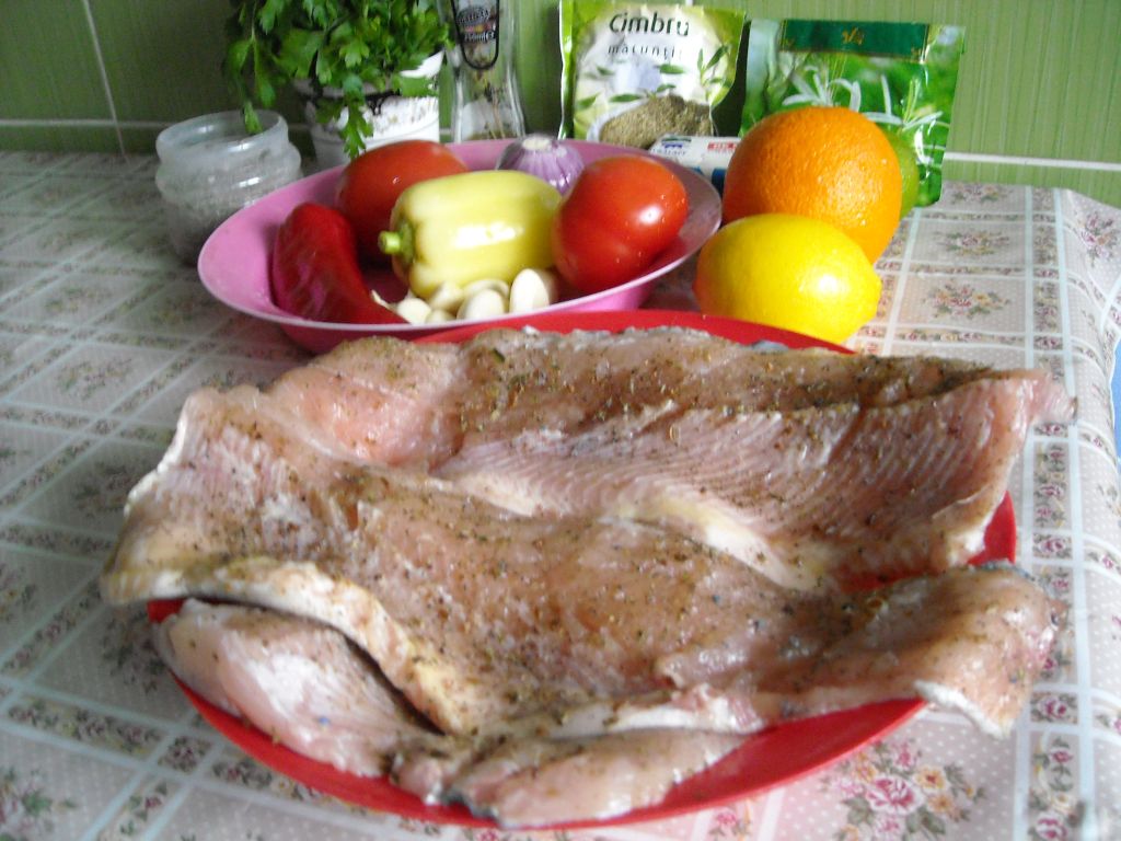 Pastrav la cuptor, pe pat de portocala, lamaie si limeta